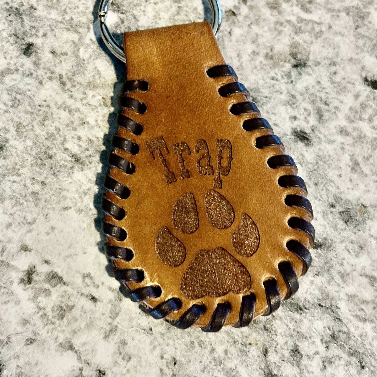 Laced leather keychain engraved with a name and paw print, by KB Custom Creations