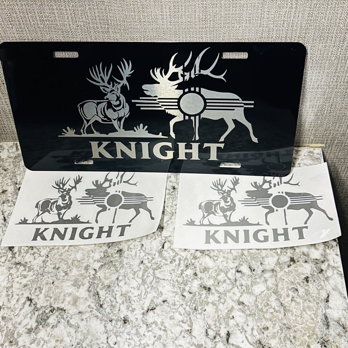 Personalized engraved license plate with deer, elk, and Zia artwork plus two matching decals, by KB Custom Creations