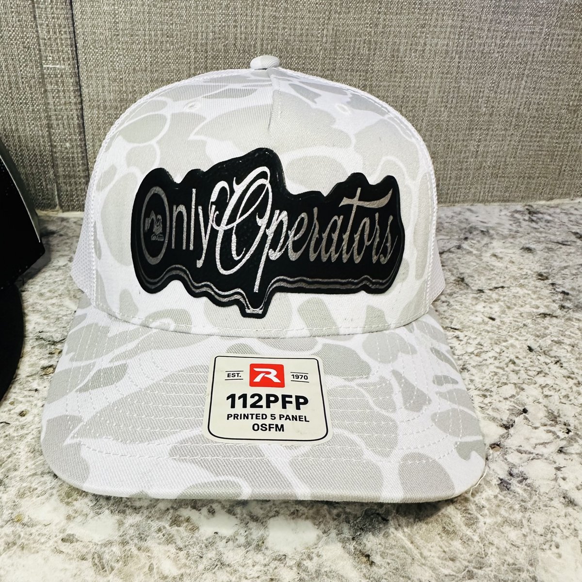 White camo Richardson hat with a black Only Operators script patch, by KB Custom Creations