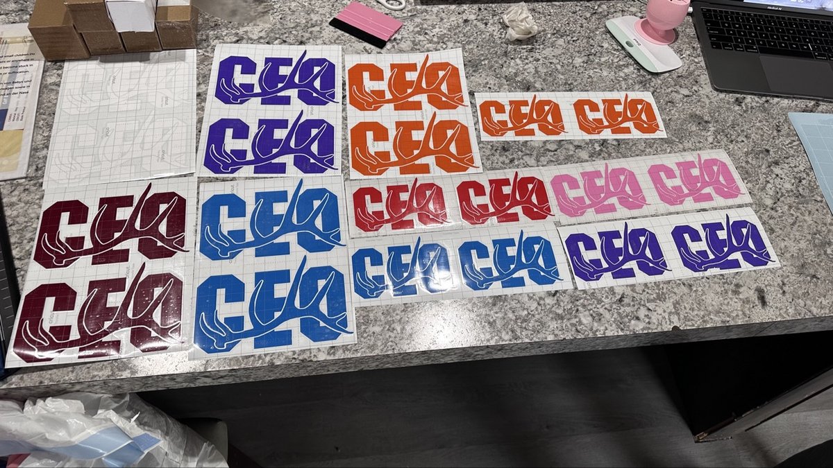Production run of CEO antler vinyl decals in many colors on a work counter, by KB Custom Creations
